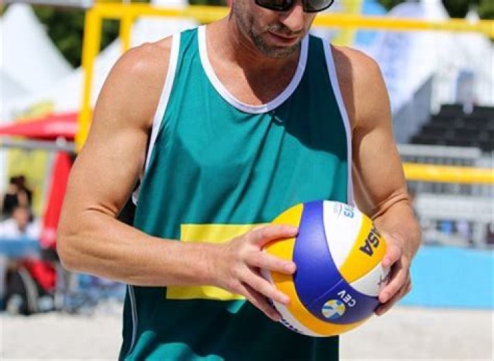 Why do volleyball players hold hands during serve?